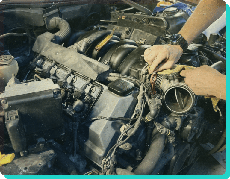 Thomas' Auto Repair and Marine Service Center in Wells, VT. Image of mechanic hands working on car engine in shop.