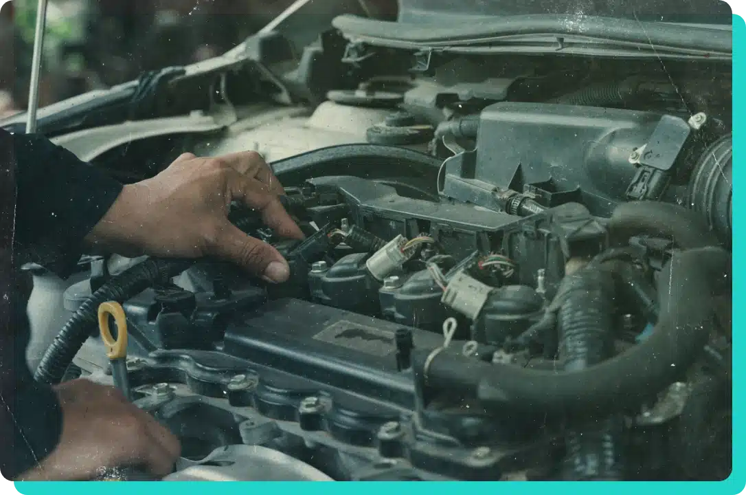 Learn about us at Thomas' auto and boat repair shop in Wells, VT. Image of mechanic hand performing work on a car engine.