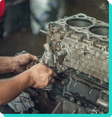 Engine Diagnostics & Repair in Wells, VT with Thomas' Auto Repair. Image of mechanic hands performing repair on an engine that has been removed from a vehicle in the shop.