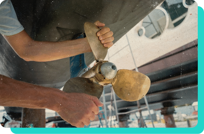 image of mechanic handling the boat motor propeller for marine services in Wells, VT.