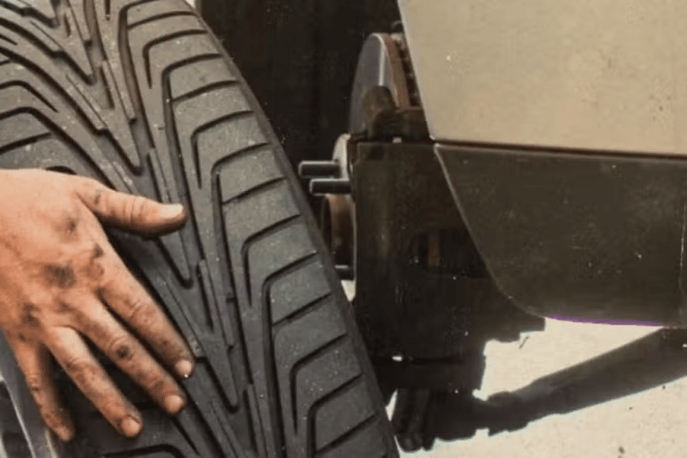 Choosing the Best Tires for Wells, VT by Thomas Auto Repair -- A mechanic's hand fits a new tire onto a vehicle during automotive maintenance.